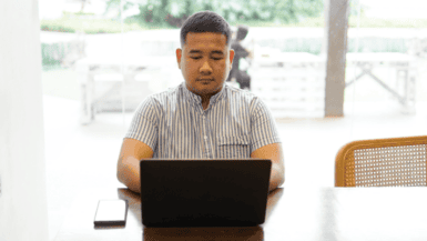 A man sitting at a table with a laptop
